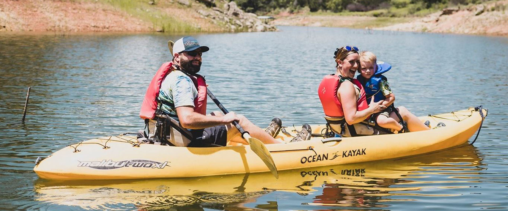 Man, women and child on a kayak in a river